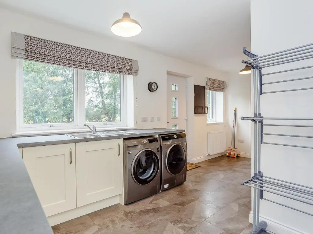 a laundry room with a washer and dryer in it at Strathclaggan in Aberlour