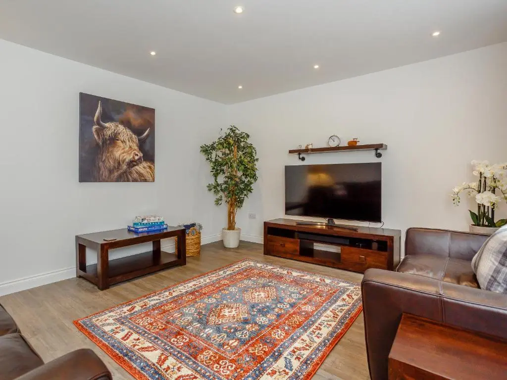 a living room with a couch and a flat screen tv at Strathclaggan in Aberlour