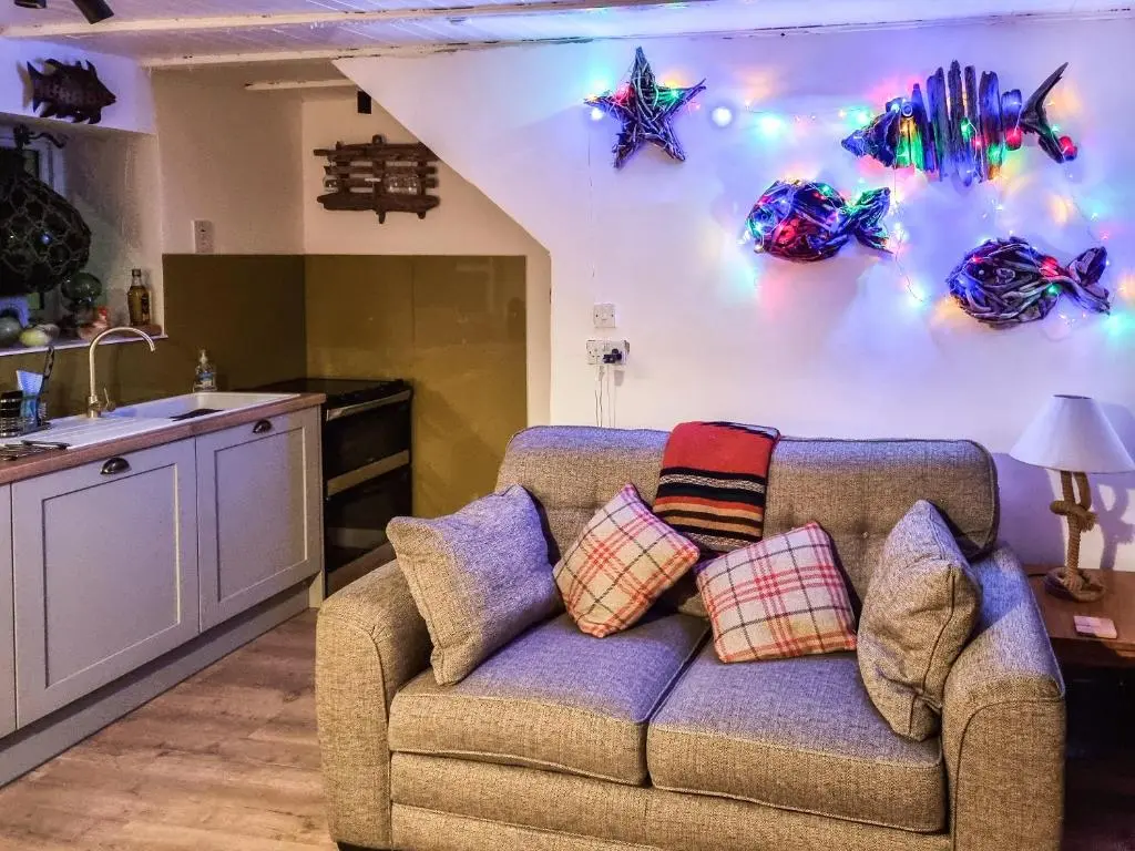 a couch in a kitchen with lights on the wall at The Windowky in Gardenstown
