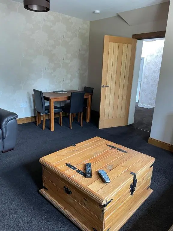 a room with a wooden table and a table and chairs at Newsagents Flat in Lairg