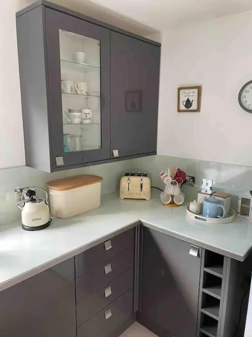 a kitchen with a counter top with cups and dishes at Corriegorm Cottage, Aviemore in Aviemore