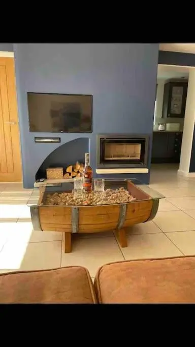 a living room with a fireplace and a table at Corriegorm Cottage, Aviemore in Aviemore