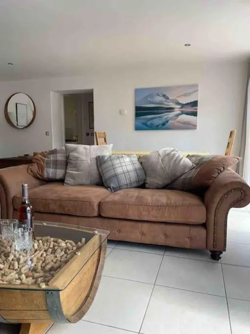 a living room with a couch and a table at Corriegorm Cottage, Aviemore in Aviemore