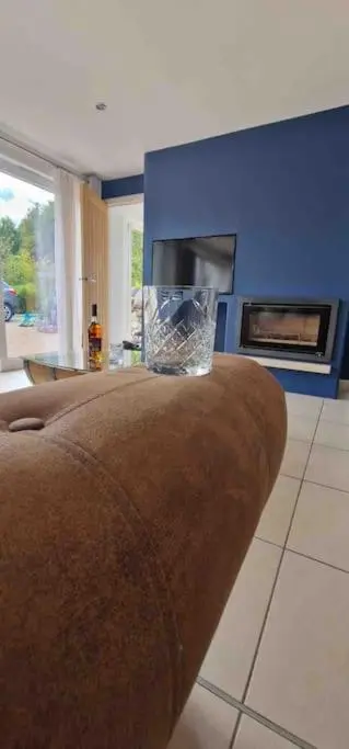 a living room with a couch and a fireplace at Corriegorm Cottage, Aviemore in Aviemore