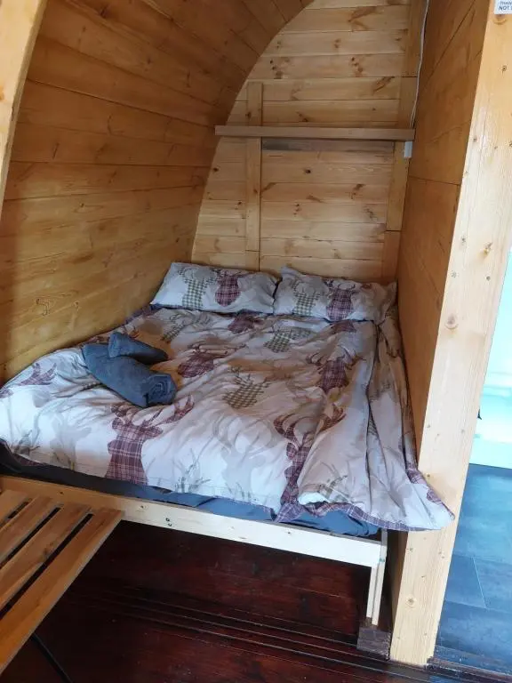 a bed in a wooden room in a cabin at Pod 4 in Skail
