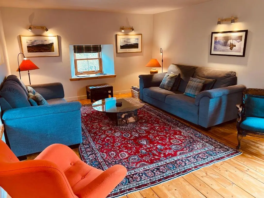 a living room with two couches and a rug at Crofts Mill in Ballater