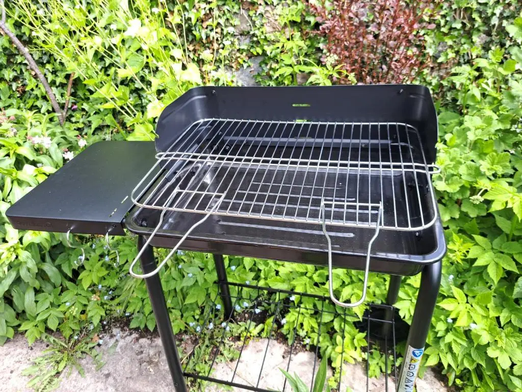 a black grill sitting in front of a bush at Clematis Cottage, Fortrose in Fortrose
