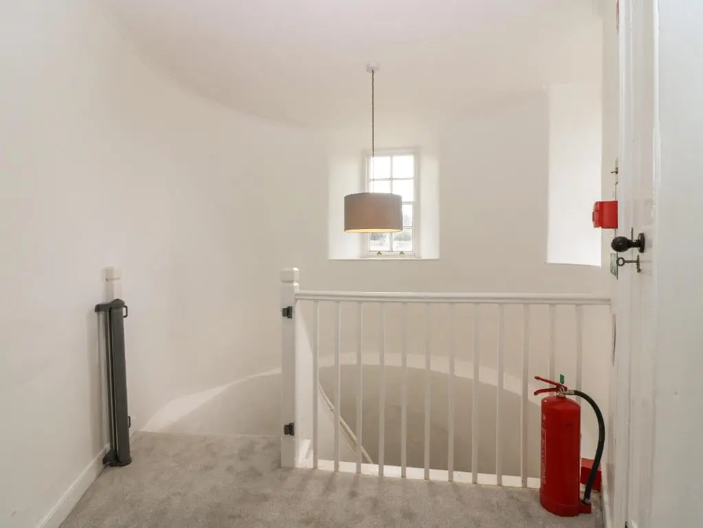 a white room with a crib and a window at East Wing - Castle Fraser in Inverurie