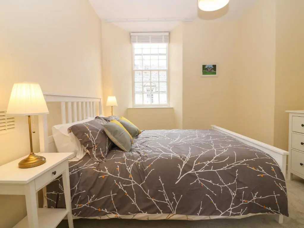 a bedroom with a bed and a table with a lamp at East Wing - Castle Fraser in Inverurie