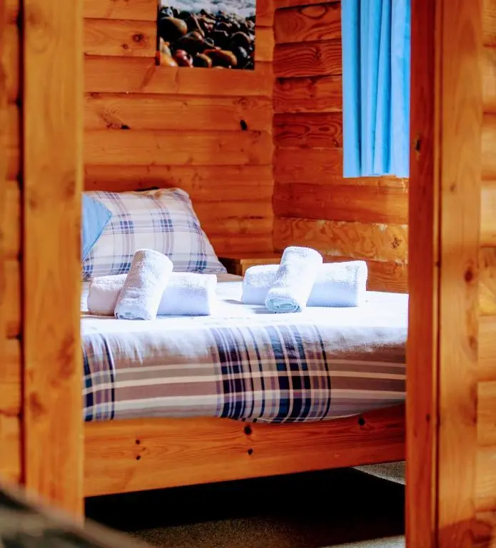 a bedroom with a bed in a log cabin at Loch Insh Chalets and Apartments in Kincraig