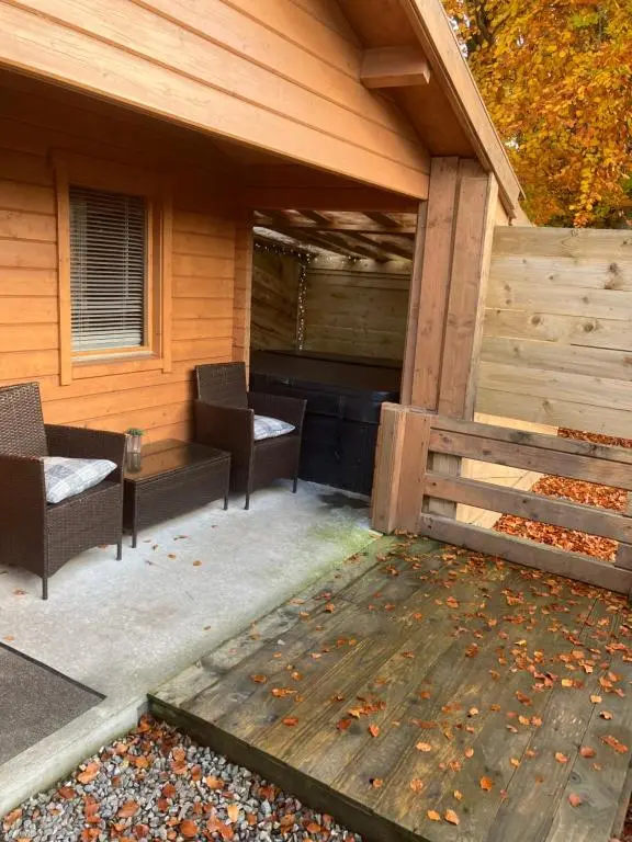 a patio with two chairs and a piano at Log Cabin in the City with hot tub in Culloden
