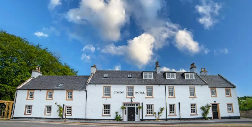 a large white building on a street at Conon Hotel in Dingwall