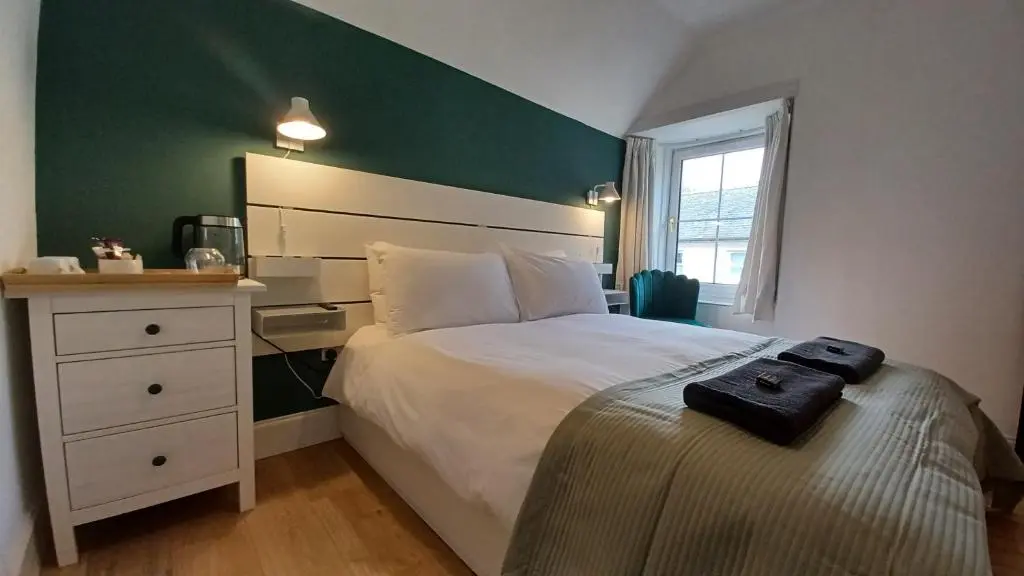 a bedroom with a bed and a green wall at Gynack Villa in Kingussie