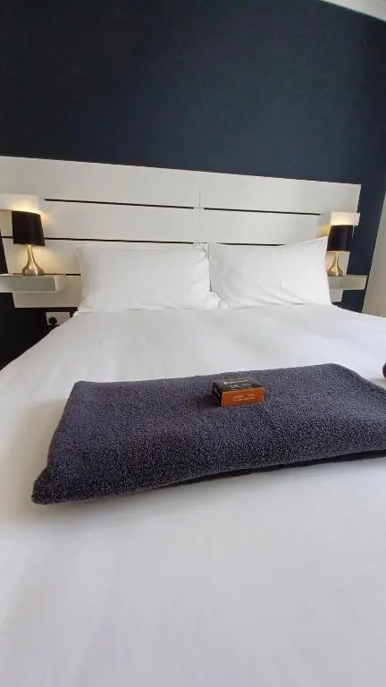 a large white bed with a book on it at Gynack Villa in Kingussie