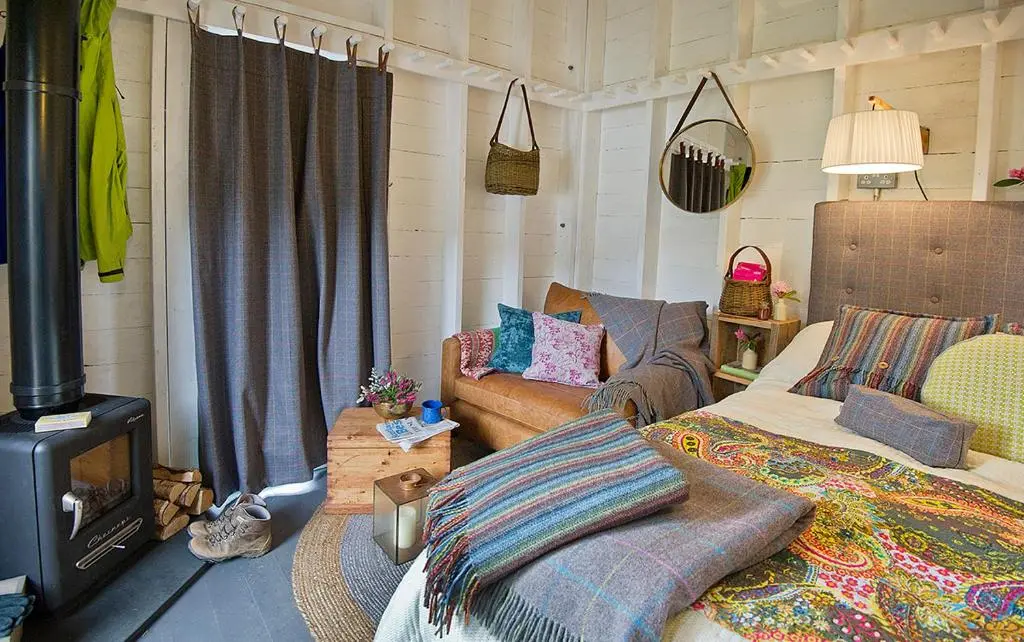 a living room with a couch and a stove at Laggan Bothies in Spean Bridge