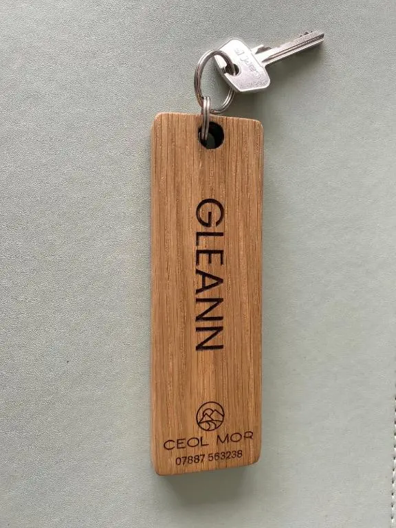 a wooden tag with a key on a wall at Ceol Mor Highland Lodges in Lairg