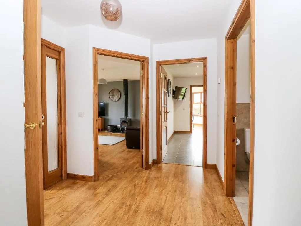 an open hallway with wooden floors and doors at Kilnary Cottage in Ellon