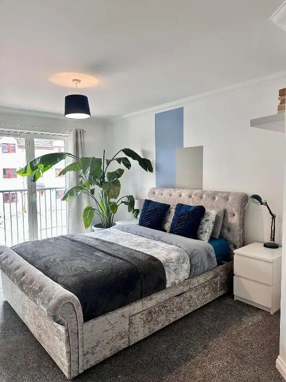 a bedroom with a large bed with blue pillows at The Meadow, River view apartment in South Kessock