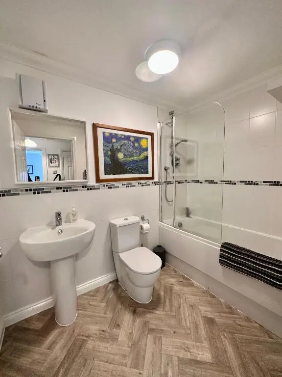 a bathroom with a toilet and a sink and a shower at The Meadow, River view apartment in South Kessock