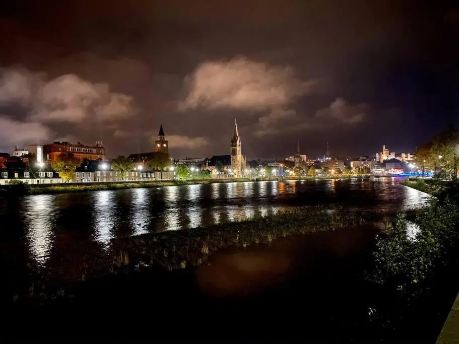 a view of a city at night with a river at The Meadow, River view apartment in South Kessock