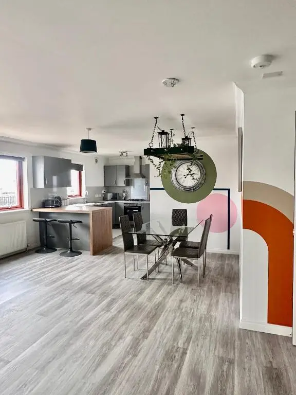 a kitchen and dining room with a table and chairs at The Meadow, River view apartment in South Kessock