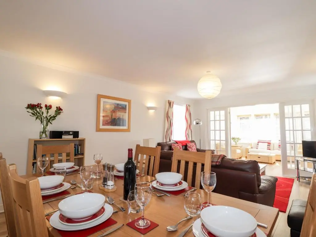 a dining room and living room with a table and chairs at Redburn Steading in Nairn