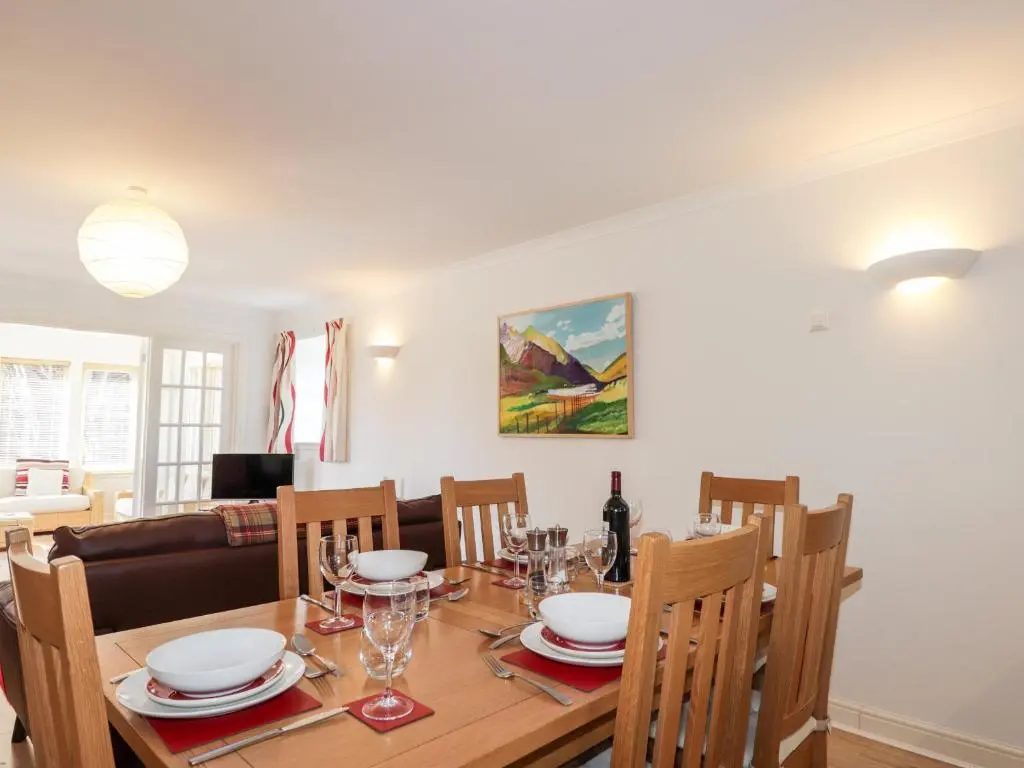 a dining room and living room with a table and chairs at Redburn Steading in Nairn