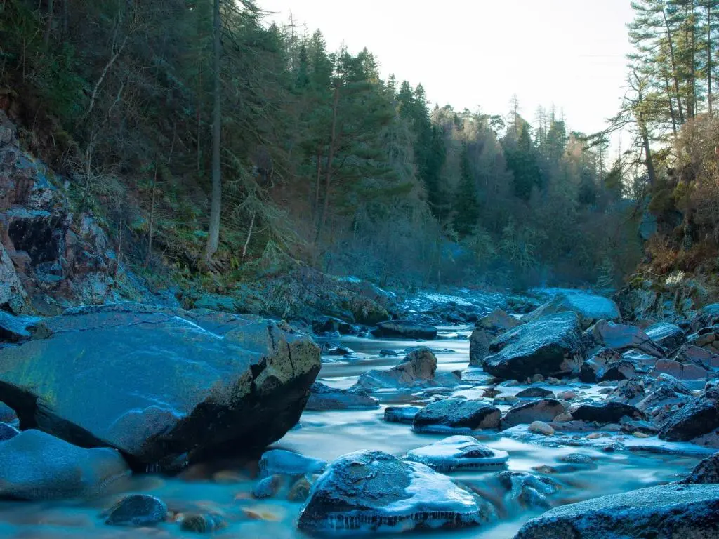 a river with rocks and trees in the background at Redburn Steading in Nairn