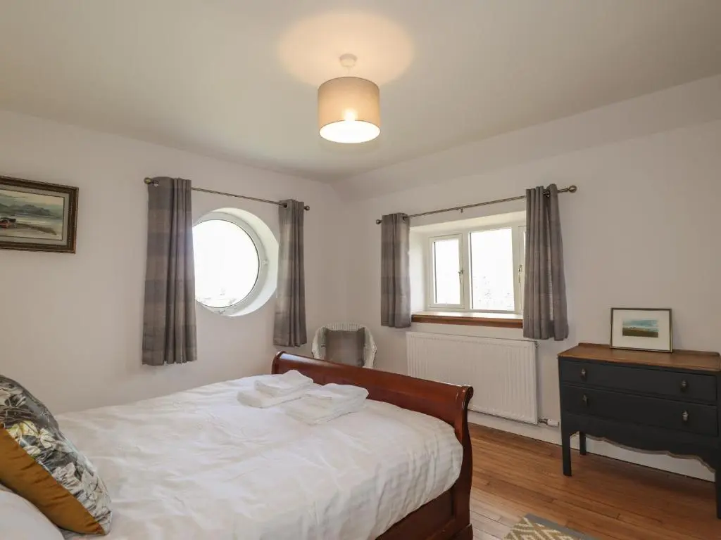 a bedroom with a bed and a window at Old Manse in Muir of Ord