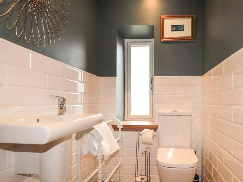 a white bathroom with a sink and a toilet at Old Manse in Muir of Ord
