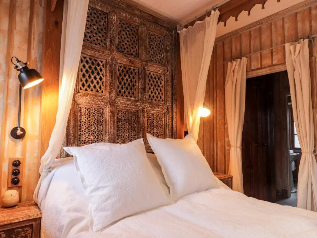a bedroom with a white bed with a wooden headboard at The Hen House in Beauly