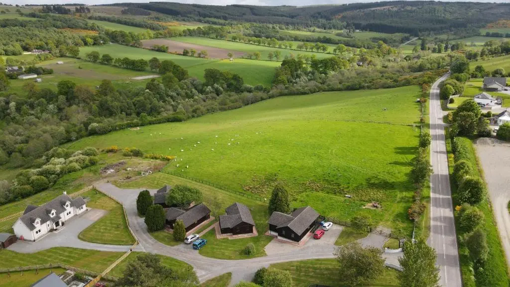 an aerial view of a house in a green field at Glenview Chalet Park in Inverness