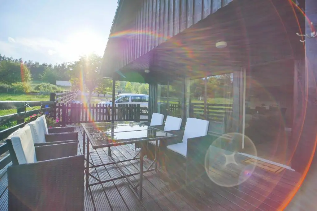 a table and chairs on a patio with the sunlight at Glenview Chalet Park in Inverness