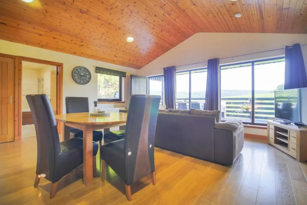 a dining room and living room with a table and a couch at Glenview Chalet Park in Inverness