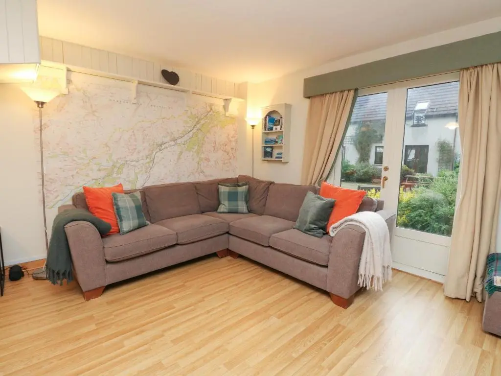 a living room with a couch and a map on the wall at The Shieling in Newtonmore