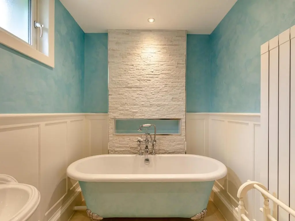a bath tub in a bathroom with blue walls at Rose Cottage - Uk39245 in Inverness