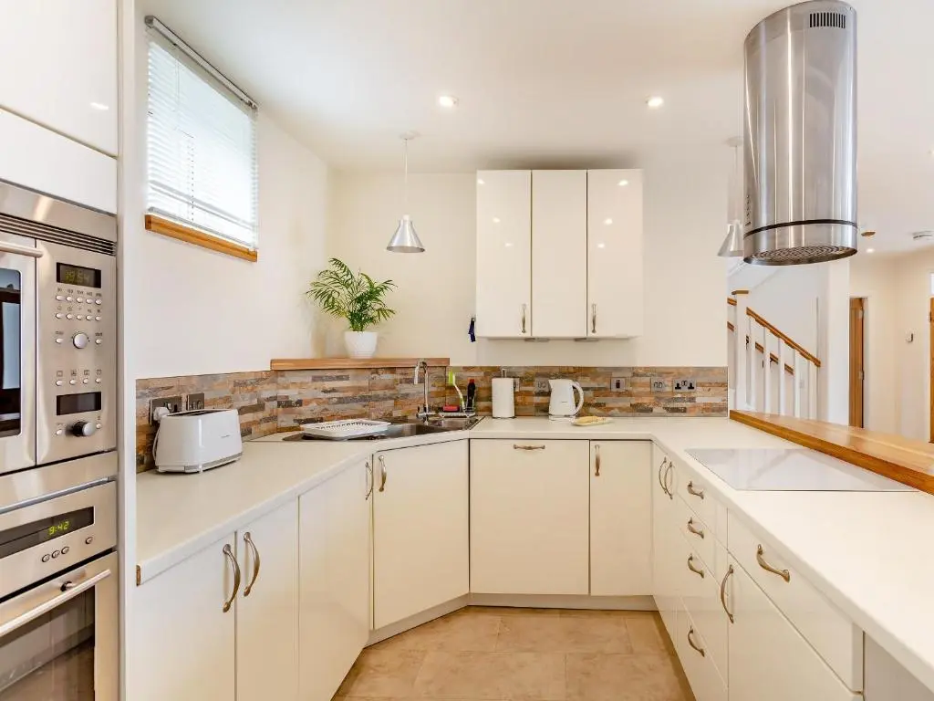 a kitchen with white cabinets and white appliances at Rose Cottage - Uk39245 in Inverness