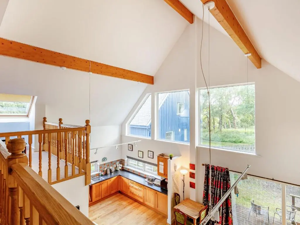 an attic room with a staircase and a large window at Osprey Cottage- Ukc5519 in Boat of Garten