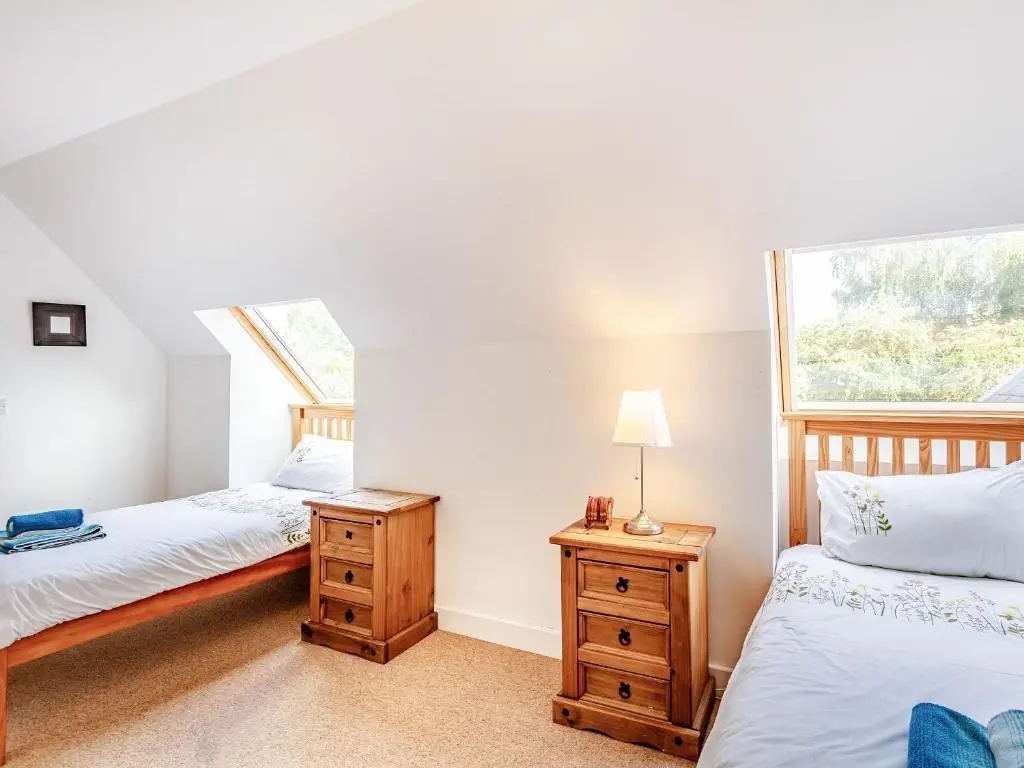 a bedroom with two beds and a window at Osprey Cottage- Ukc5519 in Boat of Garten
