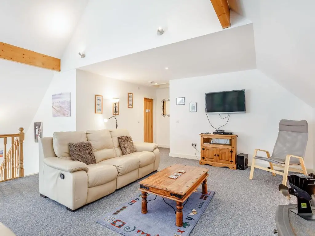 a living room with a couch and a tv at Ptarmigan Cottage-Ukc5518 in Boat of Garten