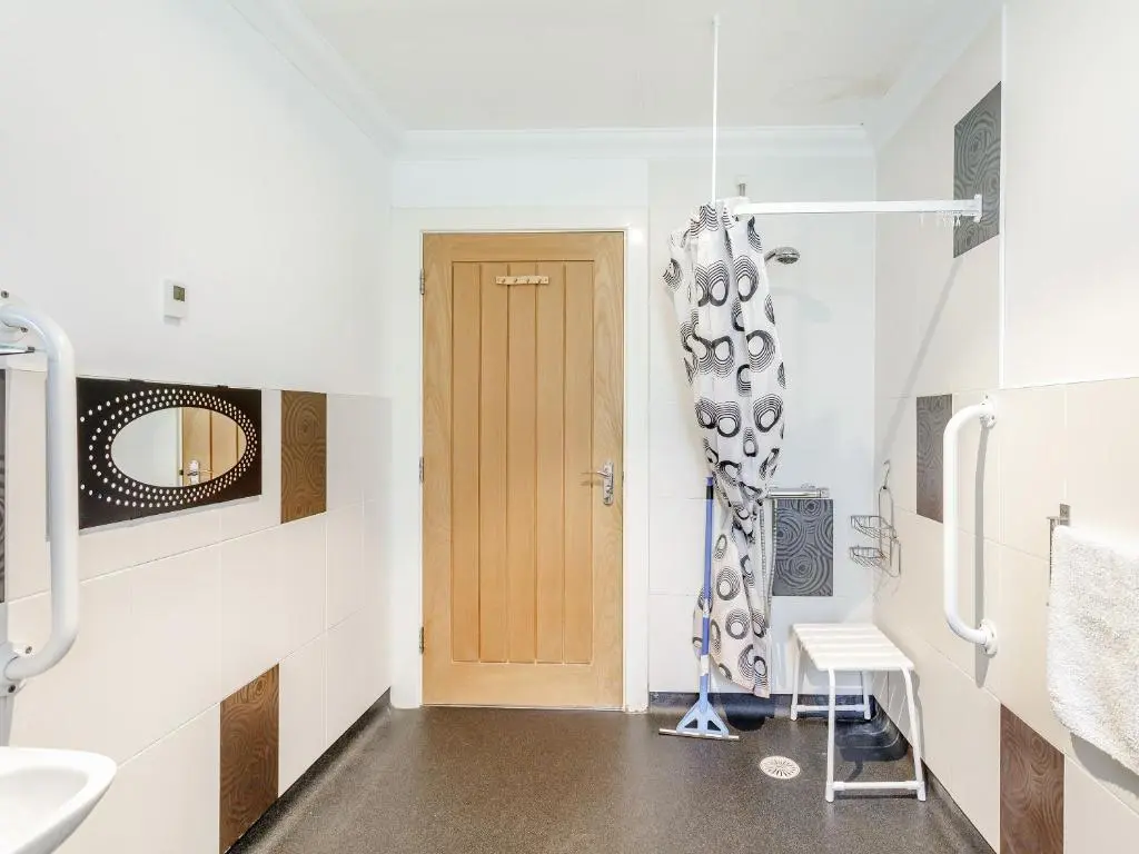 a bathroom with a toilet and a sink and a door at Ptarmigan Cottage-Ukc5518 in Boat of Garten