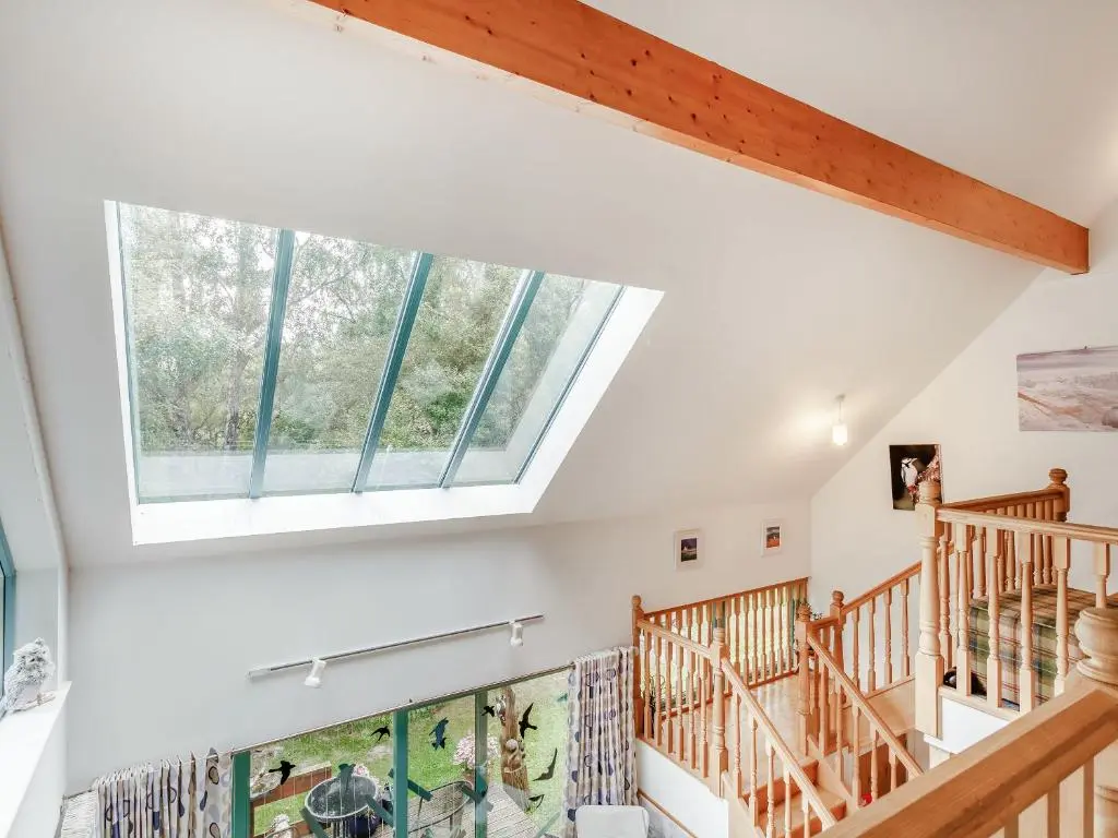 a large window in the ceiling of a room with stairs at Ptarmigan Cottage-Ukc5518 in Boat of Garten