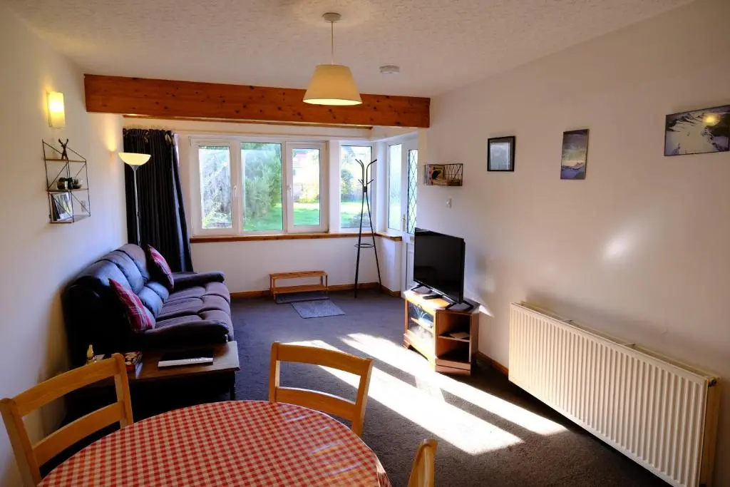 a living room with a couch and a tv at Lovely 1-bedroom apartment with free parking in Inverness