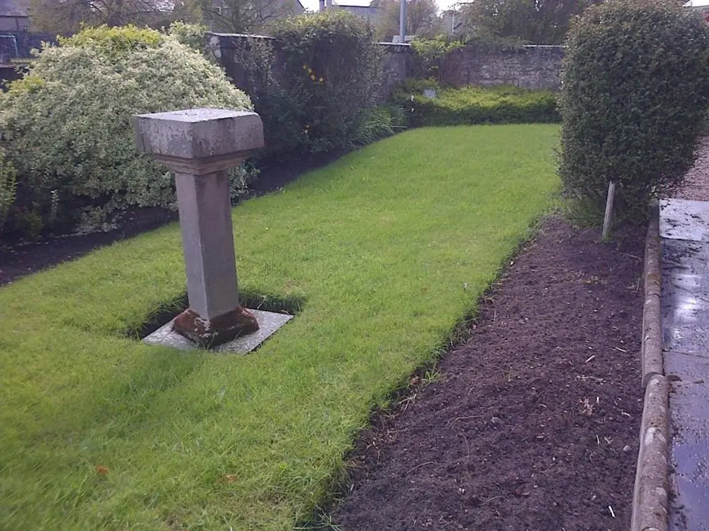 a stone birdbath in the middle of a yard at Aurora Hotel & Italian Restaurant in Nairn
