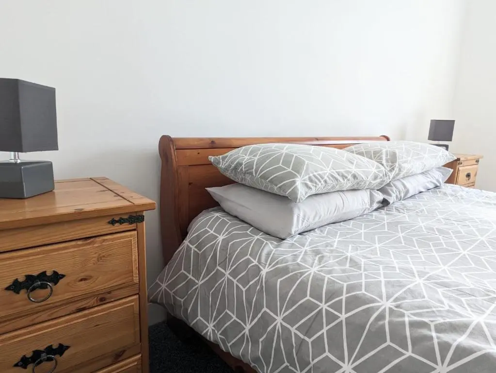 a bedroom with a bed with two pillows and a night stand at 2 Bedroom Townhouse with Seaview on the NC500 Wick in Wick