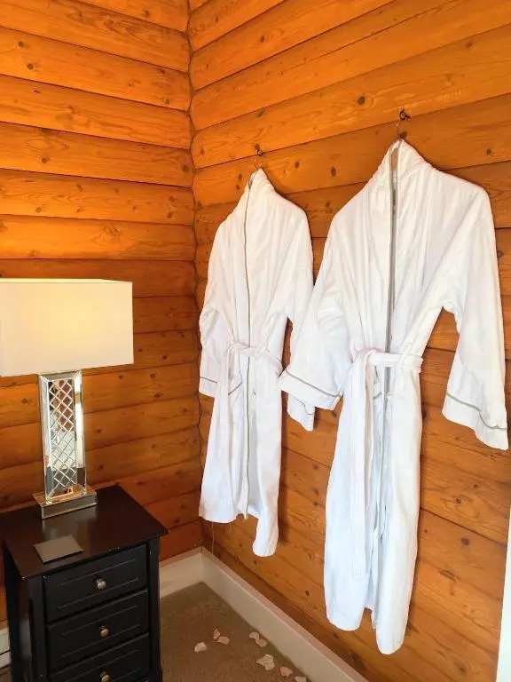 two white robes hanging on a wall in a room at Kaoglen-Stags Suite-Hot tub-Cairngorms- Dog Friendly in Balnald