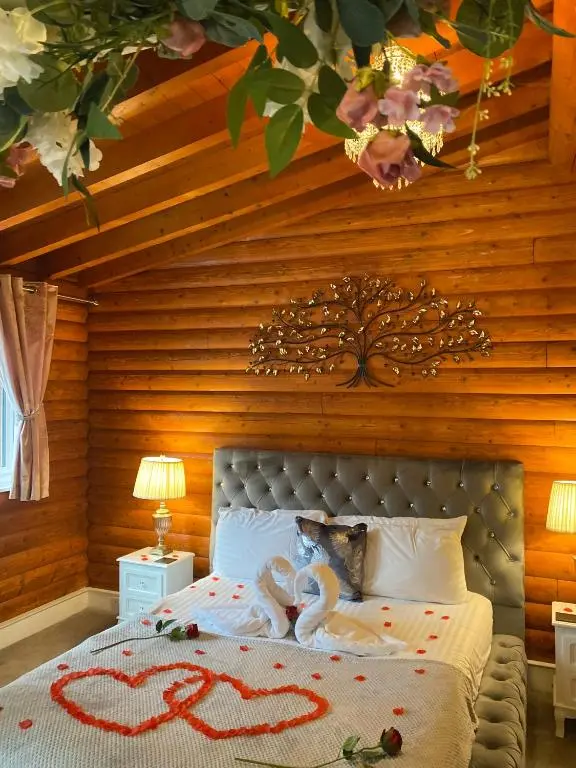 a bedroom with a bed with two swans on it at Kaoglen-Blossom-Hot tub-Cairngorms-Pet Friendly in Balnald
