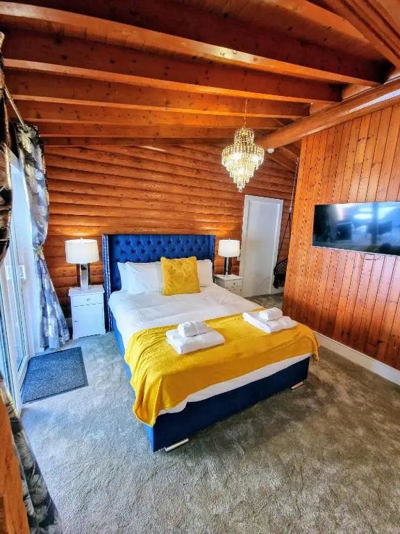 a bedroom with a bed in a wooden wall at Kaoglen Apollo-Hot tub-Cairngorms-Pet friendly in Balnald
