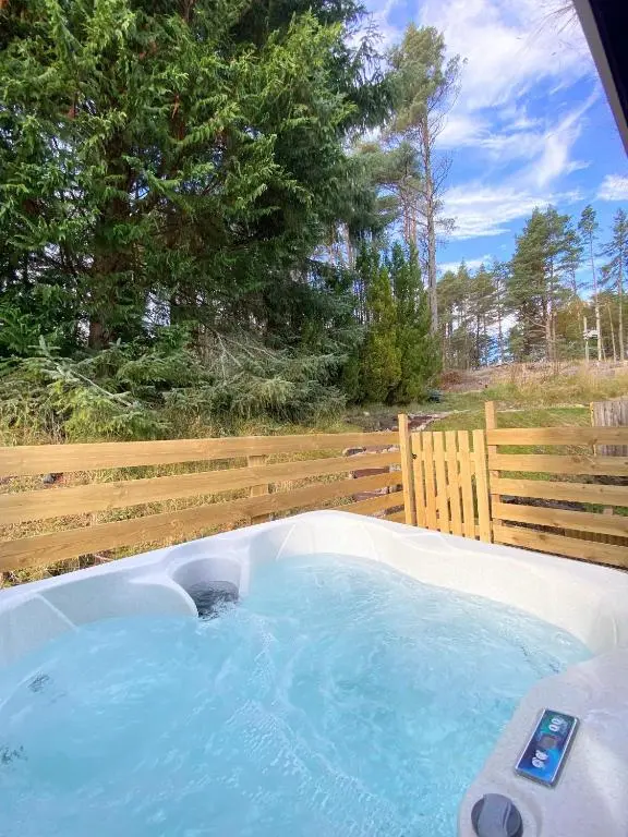 a hot tub in a backyard with a fence at kaoglen Wild-Hot tub-Cairngorms-Pet Friendly in Balnald