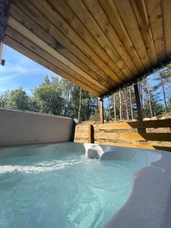 a hot tub under a wooden roof at kaoglen Wild-Hot tub-Cairngorms-Pet Friendly in Balnald